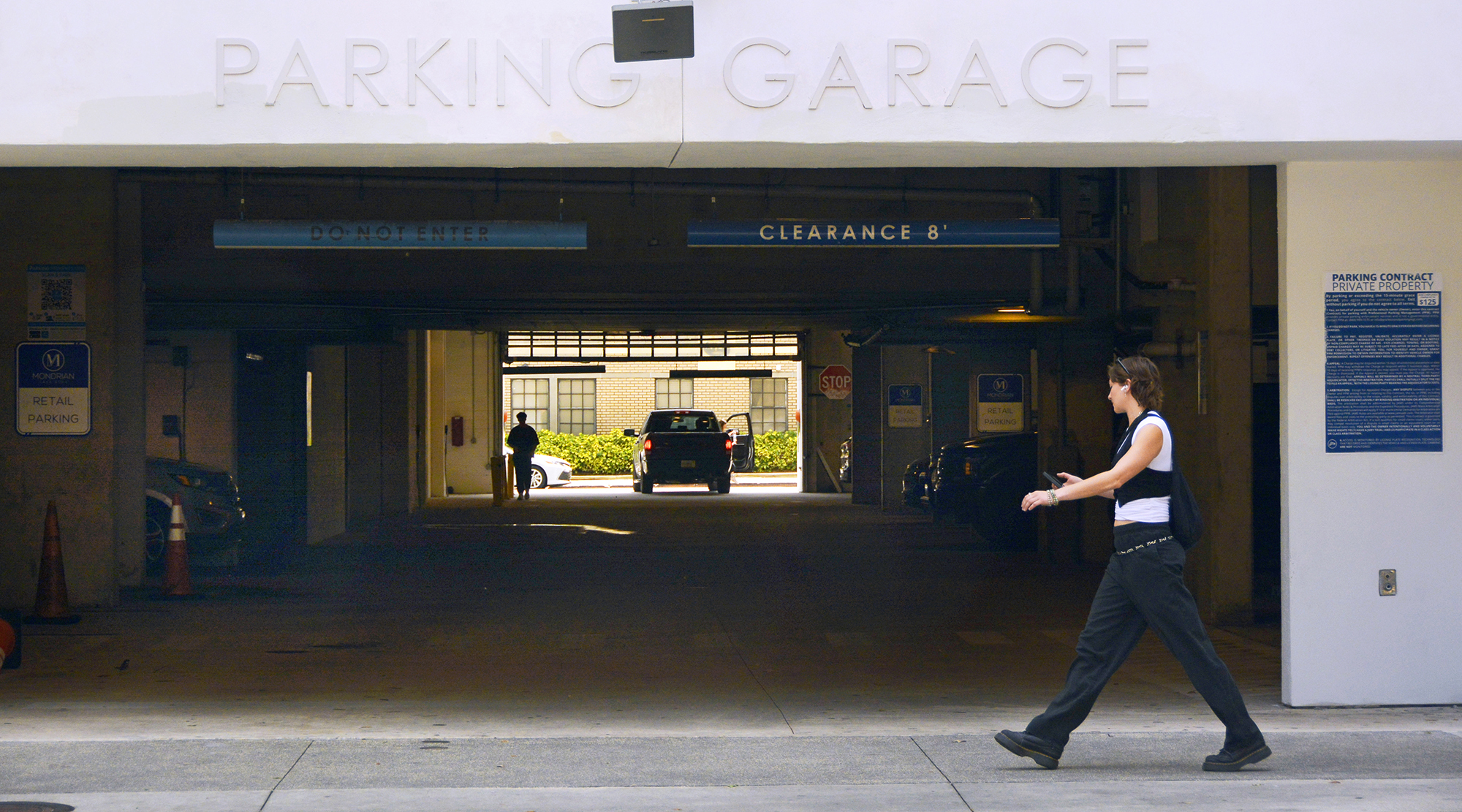 A woman walks past the entrance to a downtown Orlando parking garage.